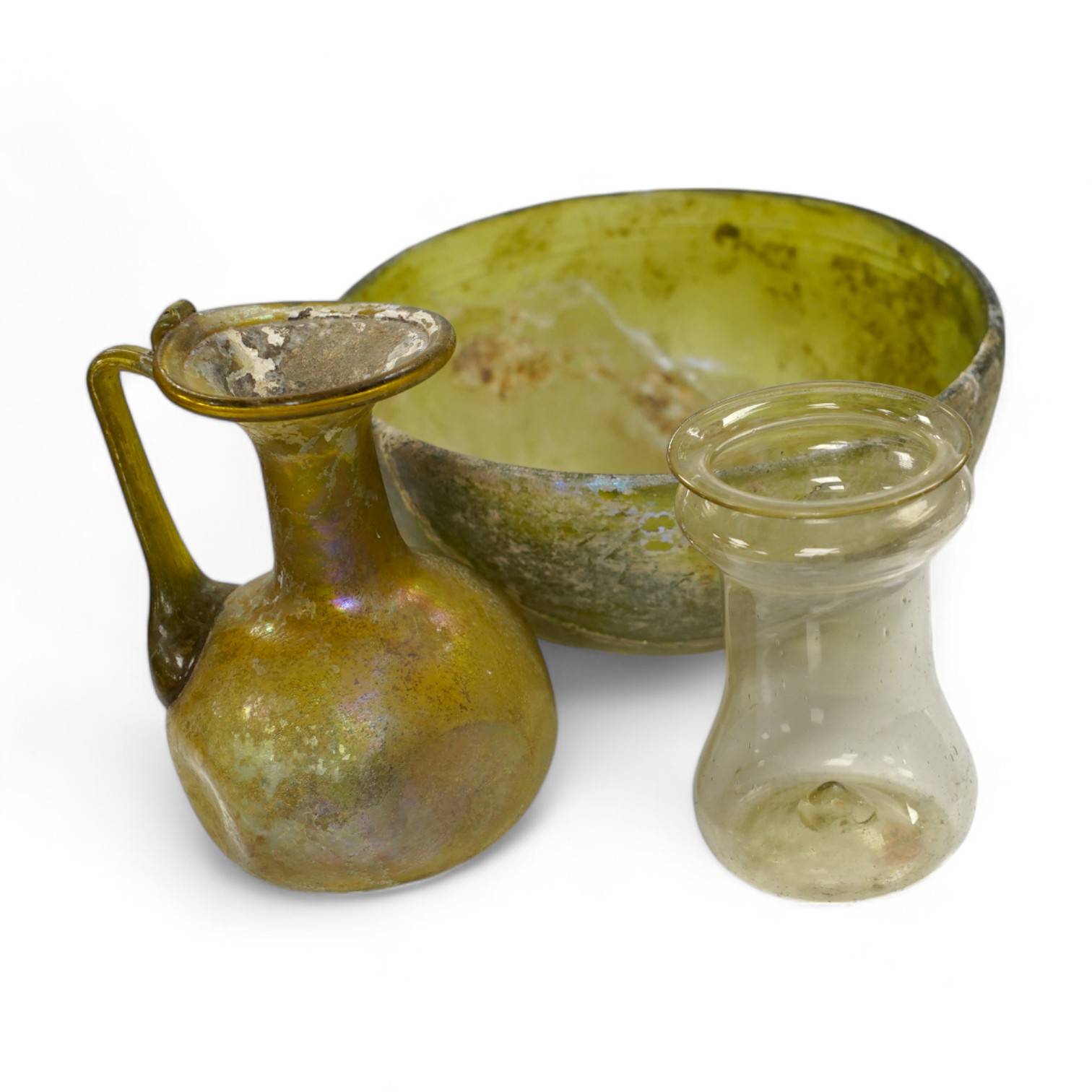 Three items of Roman glassware to include a bowl, a miniature jug and a vessel, bowl 14cm diameter. Condition - bowl repaired